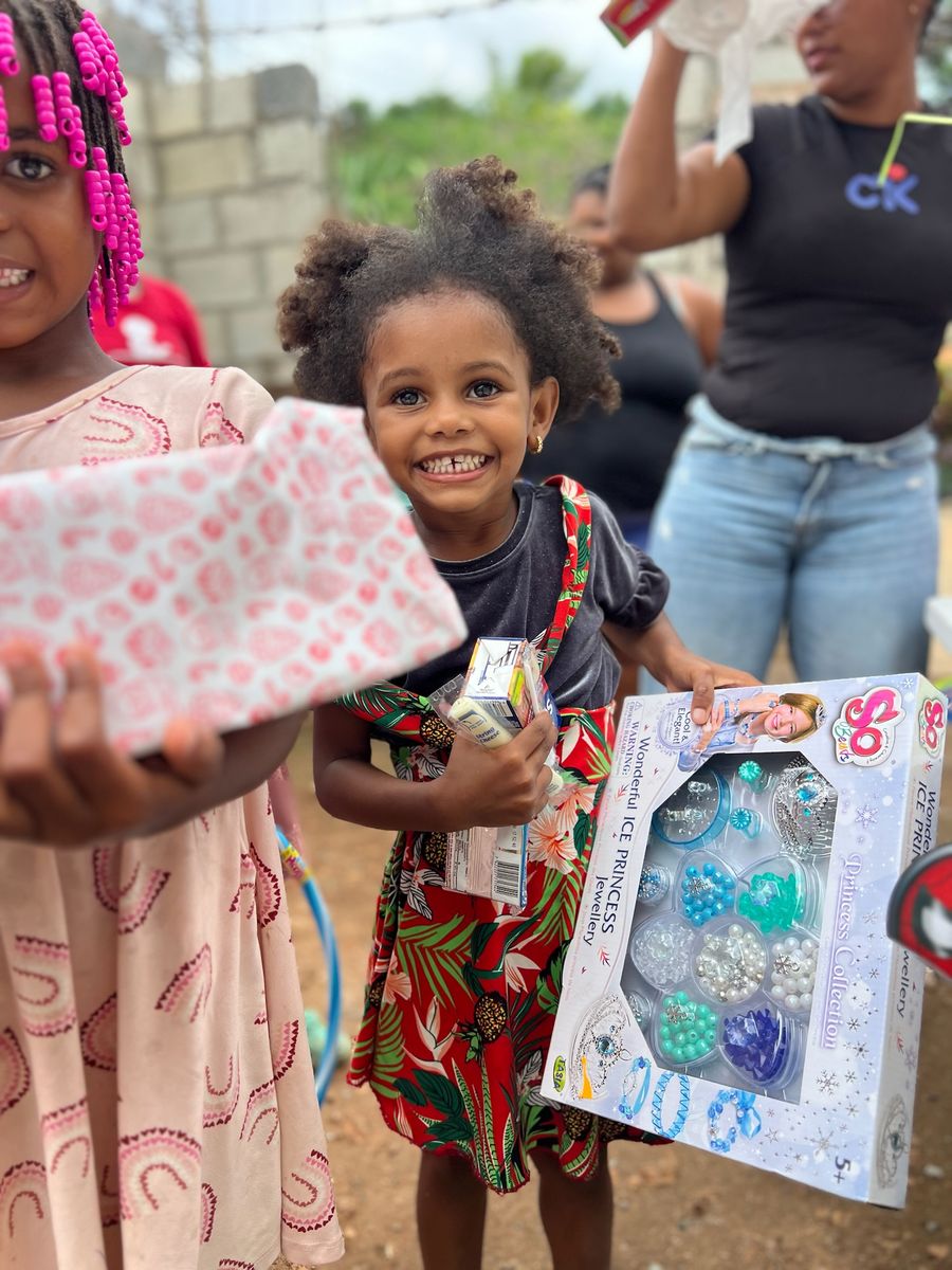 A young girl smiling with a gift at an Empower DR community event
